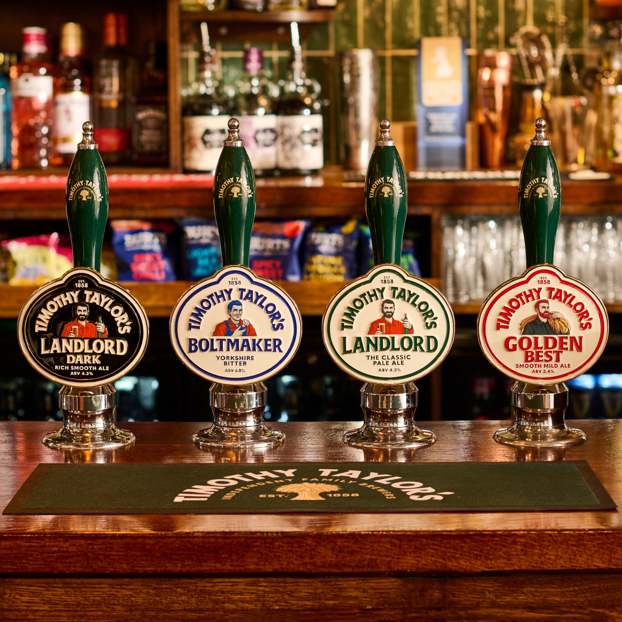 New Timothy Taylor’s pump clips and branded glassware displayed on a traditional pub bar