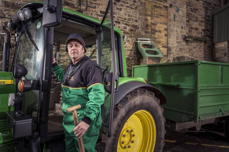 Farmer collecting spent grain from Timothy Taylor's brewery.