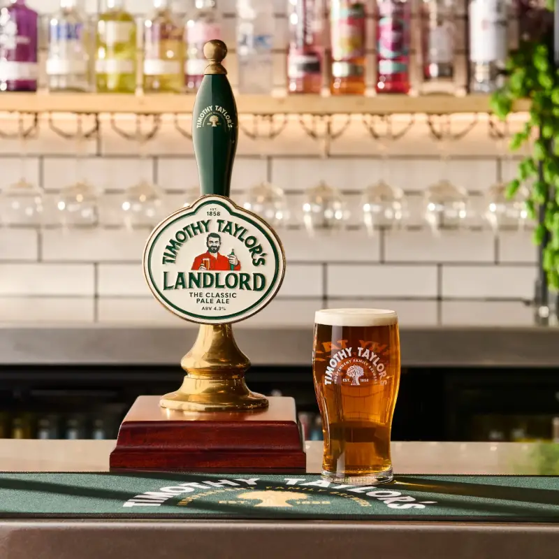 Timothy Taylor's Landlord on bar with pint glass next to pump clip.